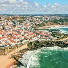 Malownicze portugalia plaże z białymi domami i czerwonymi dachami, wpadające do turkusowego oceanu. Widok z lotu ptaka na wybrzeże.