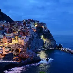 Kolorowe domy Cinque Terre, wspaniałe włochy regiony turystyczne, oświetlone nocą nad morzem.