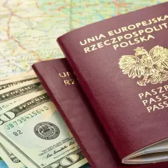 Dwa polskie paszporty, banknoty dolarowe i mapa. Planujesz podróż? Sprawdź, czy do Rumunii potrzebny jest paszport.
