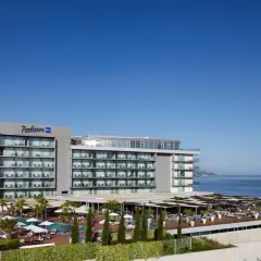 Nowoczesny hotel Radisson Blu Split z basenami i tarasami, położony nad błękitnym morzem.
