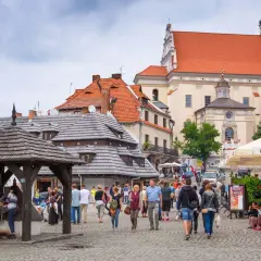 Rynek w Kazimierzu Dolnym, idealne miejsce, gdzie na wakacje w Polsce. Ludzie spacerują, podziwiając zabytkową architekturę i atmosferę.