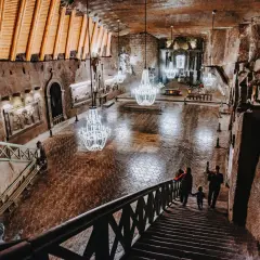 Rodzina schodzi schodami do podziemnej kaplicy w Kopalni Soli "Wieliczka". Bilety do tego cudu natury i sztuki warto kupić wcześniej.