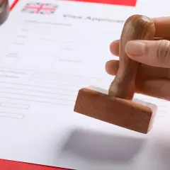 Pieczątka nad dokumentem "Visa Application" z flagą Wielkiej Brytanii. Szykuje się wiza do Londynu.