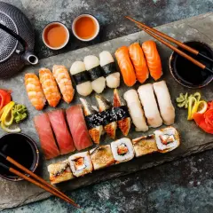 Bogactwo japońskiego jedzenia: sushi z łososiem, tuńczykiem, krewetkami, węgorzem, a także rolki i tradycyjny czajniczek.