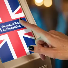 Czy do Anglii potrzebny jest paszport? Ekran z flagą Wielkiej Brytanii i napisem ETA Electronic Travel Authorization, na który wskazuje palec.