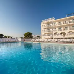 Basen z turkusową wodą i leżakami przy hotelu Barceló Aguamariina. Wysoka palma dodaje tropikalnego klimatu.