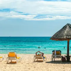 Słońce, plaża i turkusowe morze – idealne miejsce na wakacje **ultra all inclusive**. Leżaki czekają na gości.