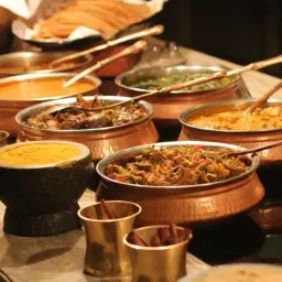 Bogactwo smaków: aromatyczne jedzenie indyjskie w miedzianych naczyniach. Curry, ryż i przyprawy kuszą zmysły.