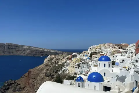 Widok na białe domy z niebieskimi kopułami na Santorini. Idealne miejsce na niezapomniane wycieczki.