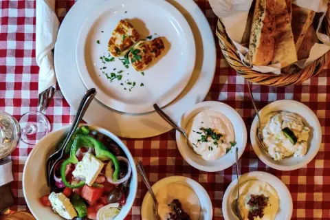 Pyszne jedzenie z Cypru: sałatka grecka, halloumi, pieczywo i dipy. Idealny posiłek na wakacjach.