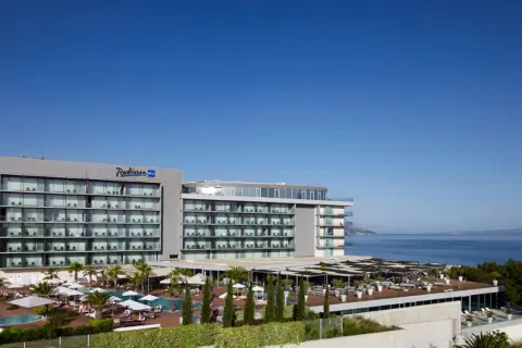 Nowoczesny hotel Radisson Blu Split z basenami i tarasami, położony nad błękitnym morzem.