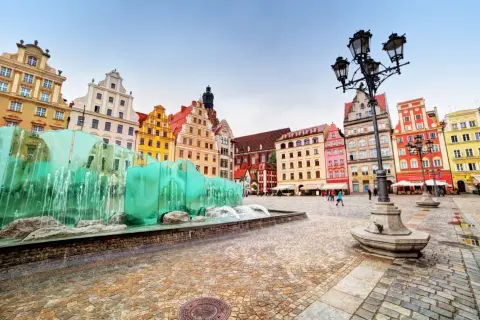 Kolorowe kamienice na Rynku we Wrocławiu, jednym z najładniejszych miast w Polsce, przy nowoczesnej fontannie.