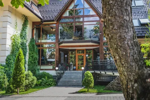 Elegancki hotel Belvedere z dużą, przeszkloną fasadą i zielenią wokół.