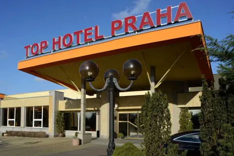 Wejście do TOP HOTEL PRAGA z charakterystycznym, pomarańczowym zadaszeniem i czerwonym napisem.