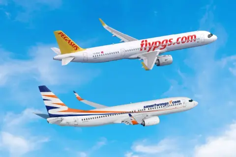 Dwa samoloty, jeden z napisem "flypgs.com" i drugi z logo Smartwings, lecą na tle błękitnego nieba. Smartwings flota w locie.