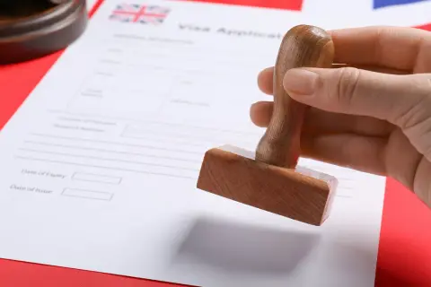 Pieczątka nad dokumentem "Visa Application" z flagą Wielkiej Brytanii. Szykuje się wiza do Londynu.