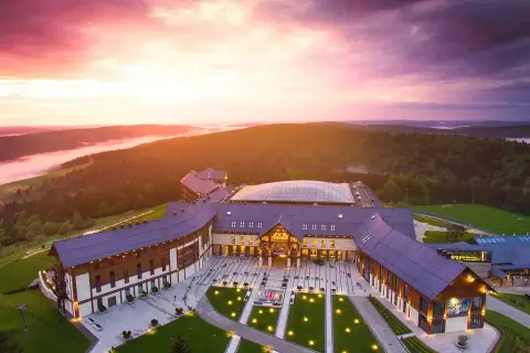Hotel Arłamów w malowniczej scenerii o zachodzie słońca. Sprawdź hotel Arłamów ceny i zaplanuj swój pobyt.