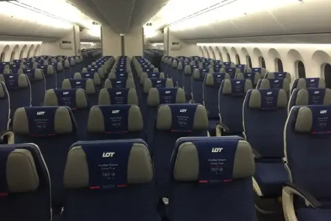 Puste siedzenia w samolocie LOT Dreamliner. Widok na rzędy niebieskich foteli z zagłówkami LOT 787-9.