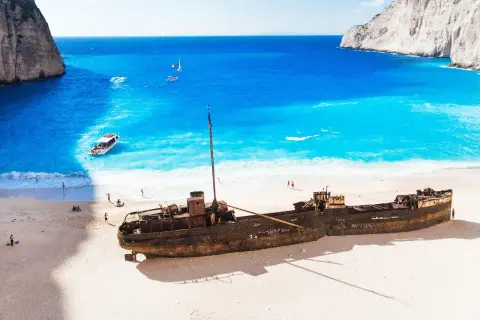 Wrak statku na plaży Navagio, idealne miejsce na kos wycieczki fakultatywne po polsku. Błękitna woda, biały piasek i klify tworzą rajski krajobraz.
