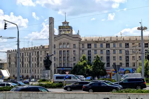 Hotel Chisinau, symbol stolicy Mołdawii, z pomnikiem i ruchem ulicznym.