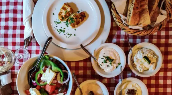 Pyszne jedzenie z Cypru: sałatka grecka, halloumi, pieczywo i dipy. Idealny posiłek na wakacjach.