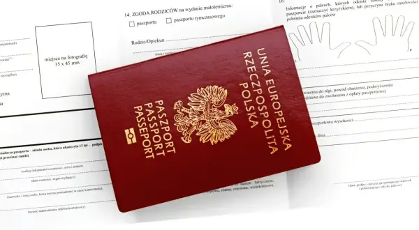 Polski paszport na tle wniosku. Dokument jest niezbędny do podróży do wielu krajów poza Unią Europejską.
