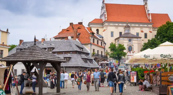 Rynek w Kazimierzu Dolnym, idealne miejsce, gdzie na wakacje w Polsce. Ludzie spacerują, podziwiając zabytkową architekturę i atmosferę.