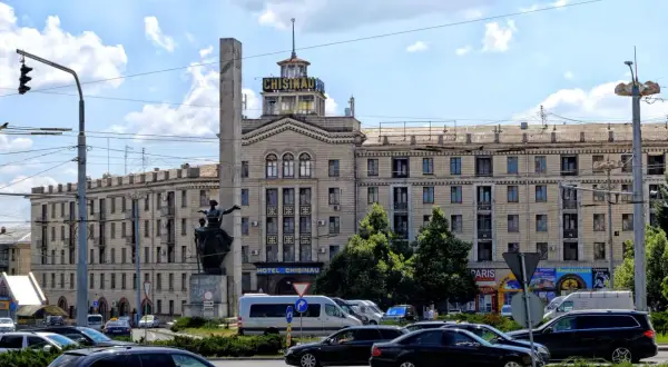 Hotel Chisinau, symbol stolicy Mołdawii, z pomnikiem i ruchem ulicznym.