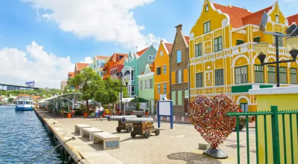 Kolorowe budynki, port i serce z kłódek – idealne miejsce na curacao wakacje.