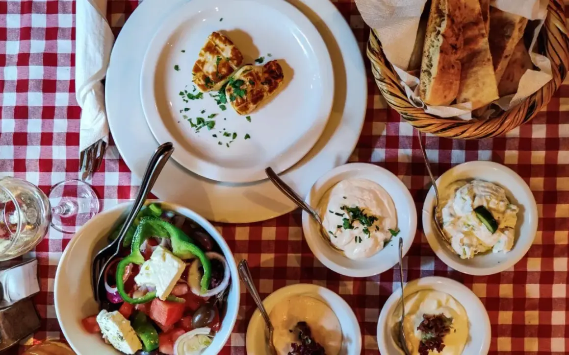 Pyszne jedzenie z Cypru: sałatka grecka, halloumi, pieczywo i dipy. Idealny posiłek na wakacjach.