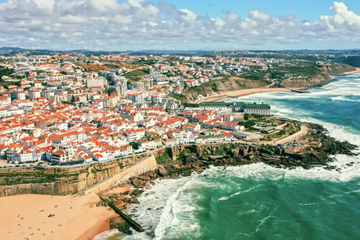 Malownicze portugalia plaże z białymi domami i czerwonymi dachami, wpadające do turkusowego oceanu. Widok z lotu ptaka na wybrzeże.
