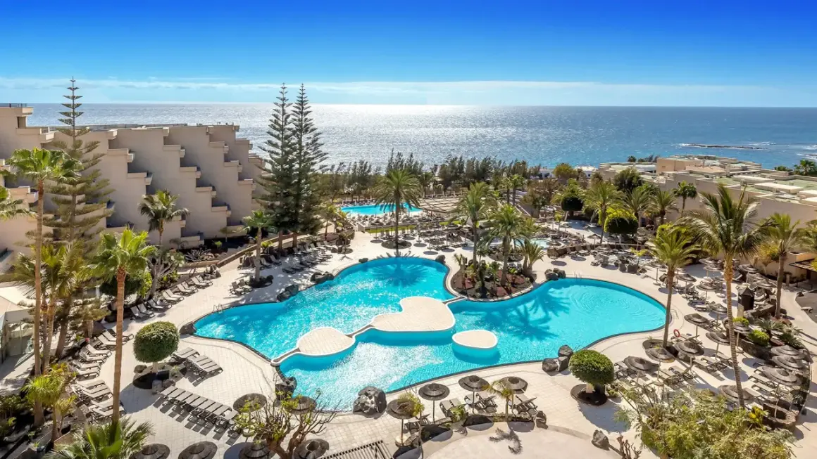 Barceló Lanzarote Active Resort: luksusowy kompleks z basenami, palmami i widokiem na ocean. Idealne miejsce na aktywny wypoczynek.