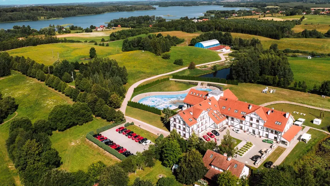 Malowniczy widok na narie resort & spa z basenem, budynkami i parkingiem pełnym samochodów.