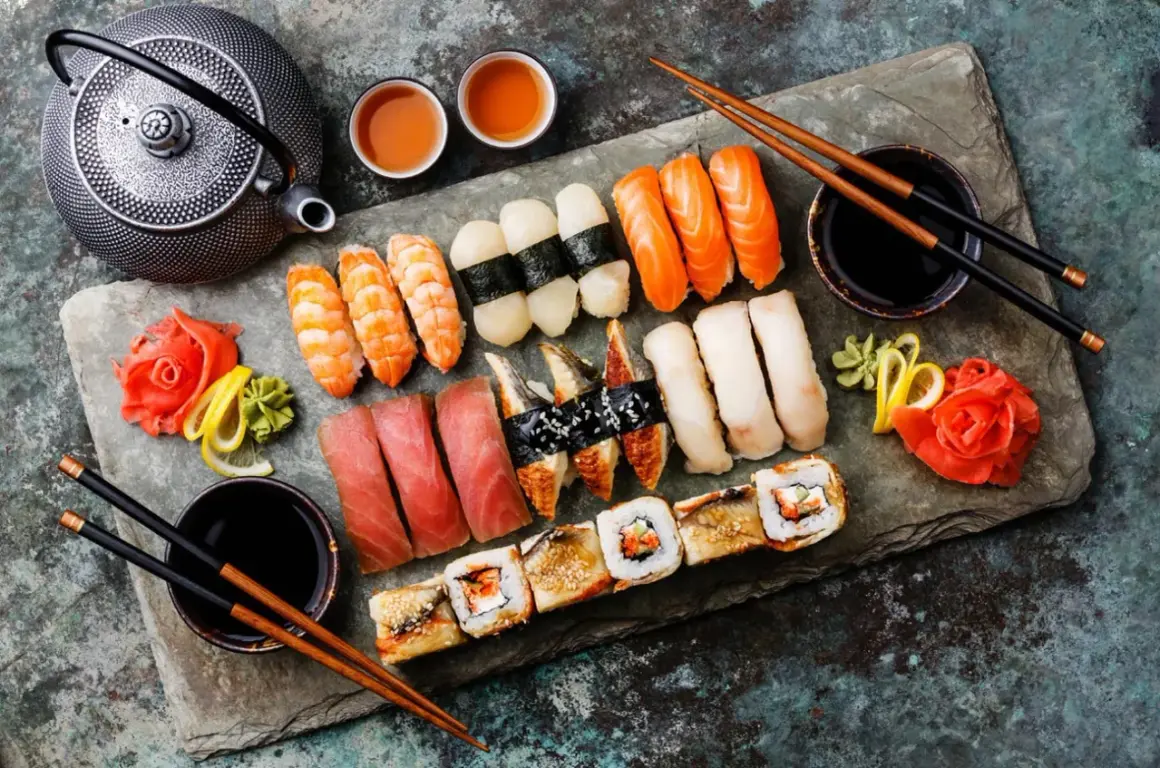 Bogactwo japońskiego jedzenia: sushi z łososiem, tuńczykiem, krewetkami, węgorzem, a także rolki i tradycyjny czajniczek.