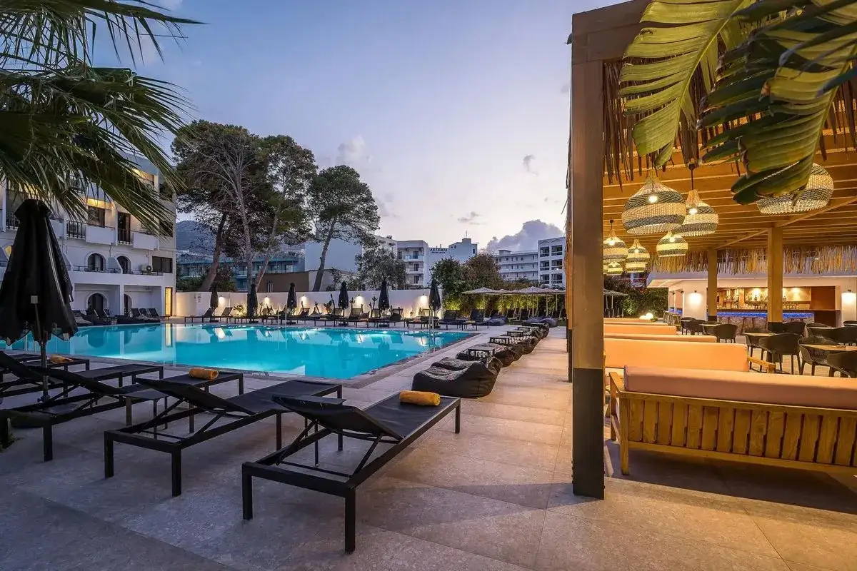 Basen i bar w Heronissos Hotel Kreta. Leżaki, palmy i stylowe oświetlenie tworzą wakacyjny klimat.