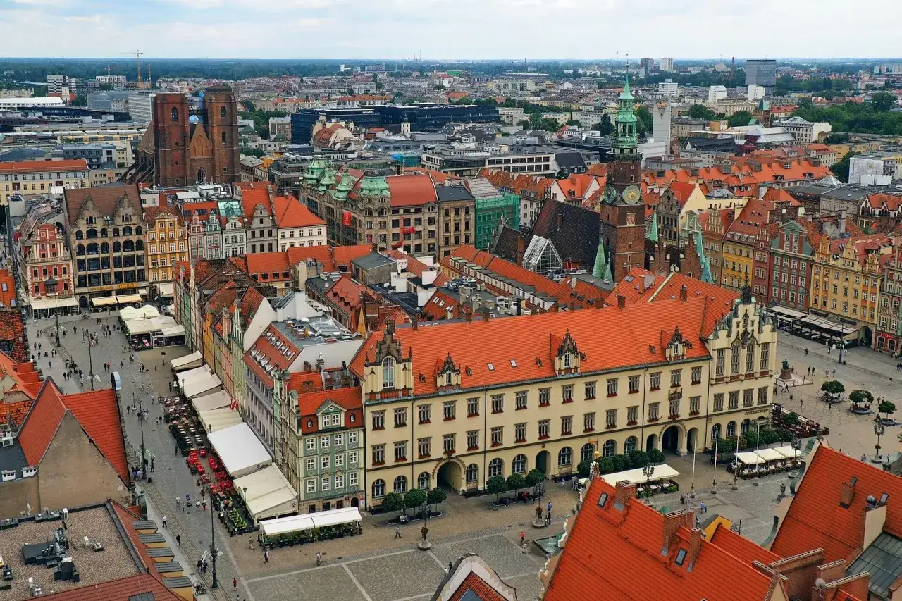 Wrocławski Rynek, jeden z najładniejszych miast w Polsce, tętni życiem. Kamienice z czerwonymi dachami tworzą malowniczy krajobraz.