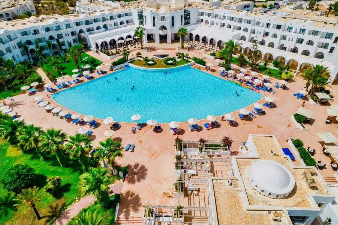 Relaks przy basenie w club palm azur djerba. Słońce, palmy i błękitna woda zapraszają do wypoczynku.