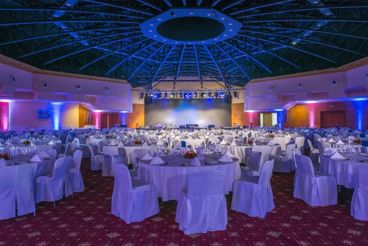 Elegancka sala bankietowa z okrągłymi stołami, przygotowana na uroczystość. To idealne miejsce na wydarzenie w top hotel praga.