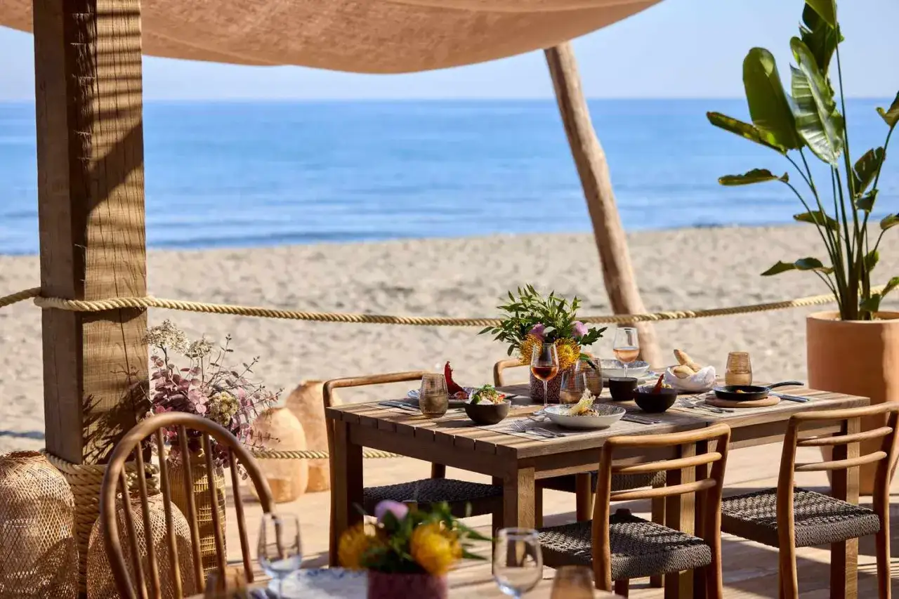 Stół z jedzeniem i winem na plaży, idealny na wakacje ultra all inclusive.