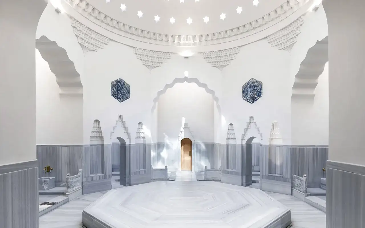 Elegancki, marmurowy hamam z ozdobnymi detalami i gwiazdami na suficie.