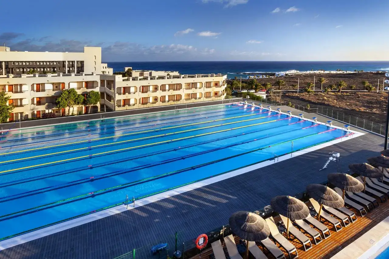 Basen olimpijski w Barceló Lanzarote Active Resort, z widokiem na ocean. Idealne miejsce na trening i relaks.