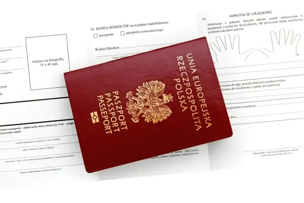 Polski paszport na tle wniosku. Dokument jest niezbędny do podróży do wielu krajów poza Unią Europejską.