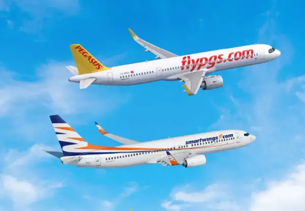 Dwa samoloty, jeden z napisem "flypgs.com" i drugi z logo Smartwings, lecą na tle błękitnego nieba. Smartwings flota w locie.