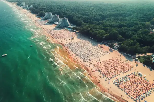 Tłok na plaży podczas wycieczki do Bułgarii. Tysiące parasoli i ludzi kąpiących się w morzu.
