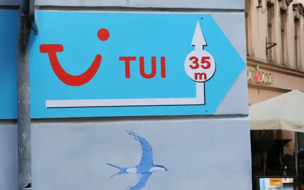 Niebieski szyld TUI z logo i strzałką wskazuje drogę do biura podróży, 35m. Może to być znak, że czas na rezygnację z wycieczki i powrót do domu.