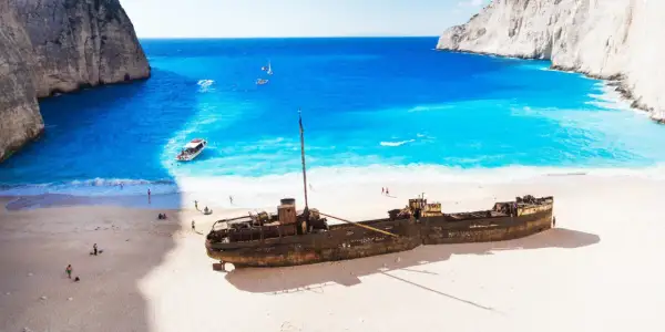 Wrak statku na plaży Navagio, idealne miejsce na kos wycieczki fakultatywne po polsku. Błękitna woda, biały piasek i klify tworzą rajski krajobraz.