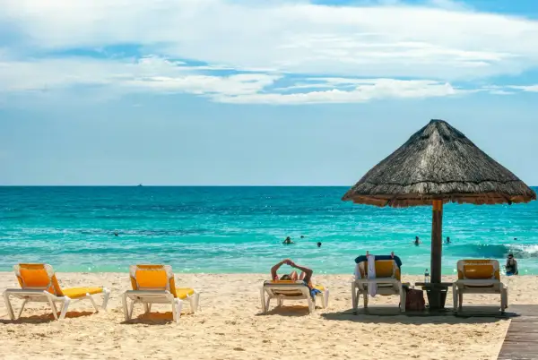 Słońce, plaża i turkusowe morze – idealne miejsce na wakacje **ultra all inclusive**. Leżaki czekają na gości.