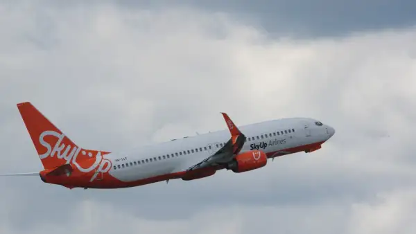Samolot SkyUp Airlines wznosi się na tle pochmurnego nieba.